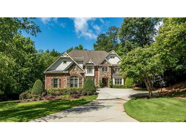 Elegant brick and stone two-story home with a manicured lawn and a circular driveway at 5284 Vernon Springs Nw Trl, Sandy Springs, GA 30327
