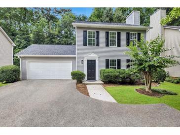 Charming two-story home with gray siding, black shutters, attached garage, and well-manicured lawn at 4800 Countryside E, Stone Mountain, GA 30083