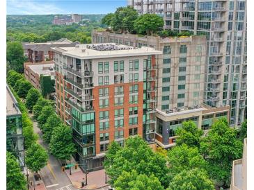 Multi-story condo building with brick facade, balconies, and surrounding trees and city views at 867 Peachtree Ne St # 702, Atlanta, GA 30308