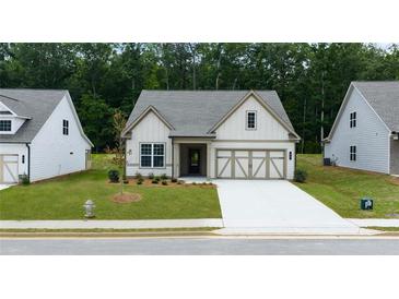 Charming one-story home with a well-manicured lawn and a two-car garage in a suburban neighborhood at 48 Mayhaw Pt, Sharpsburg, GA 30277