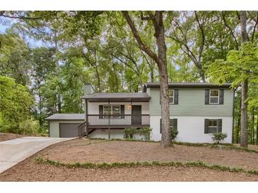Inviting two-story home with a charming front porch and a well-maintained landscaped yard at 3288 Tarragon Dr, Decatur, GA 30034