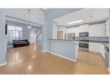 Open-concept living room featuring hardwood floors, stylish decor, and a seamless transition to the modern kitchen at 5013 Centennial Commons Nw Dr, Acworth, GA 30102