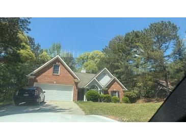 Charming brick home with a well-maintained lawn and a two-car garage at 3510 Hog Mountain Rd, Dacula, GA 30019