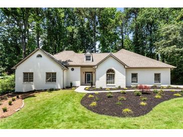 Charming white brick home features manicured landscaping and a lush green lawn at 251 Waller Nw Cir, Marietta, GA 30064