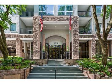 Inviting condominium building entrance with elegant stone facade and manicured landscaping at 275 13Th Ne St # 201, Atlanta, GA 30309