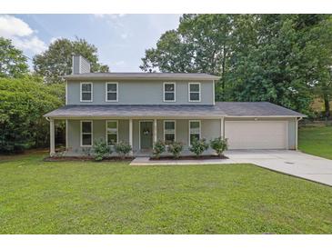 Charming two-story home with a well-manicured lawn, inviting front porch, and attached two-car garage at 5515 Pennybrook Trl, Stone Mountain, GA 30087