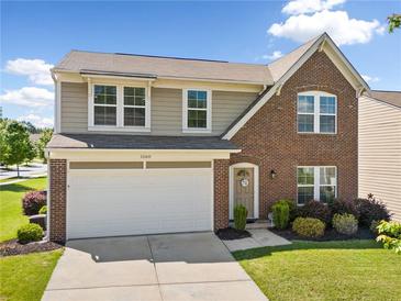 Charming two-story home featuring a brick facade, two-car garage, and a well-manicured lawn with tasteful landscaping at 1560 Avalon Creek Rd, Sugar Hill, GA 30518