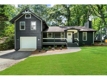 Charming home with a well-manicured lawn, attached garage and a cozy front porch at 1690 Eaglecreek Trl, Cumming, GA 30041