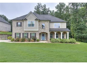 Charming two-story home features manicured lawn, blue front door and well-maintained landscaping at 116 Chorley Run, Ellenwood, GA 30294