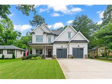 Charming two-story home with a landscaped lawn and a two-car garage on a beautiful sunny day at 1442 Pierce Se Ave, Smyrna, GA 30080