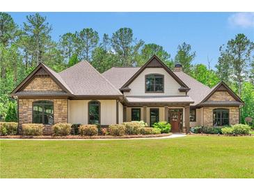 Beautiful single-Gathering home featuring a manicured lawn and a charming stone and siding exterior at 35 Cornish Creek Ln, Covington, GA 30014