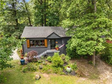 Charming single-story home with a dark gray exterior, landscaped front yard, and shutters surrounded by lush trees at 2468 Fallview Ter, Atlanta, GA 30344
