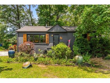 Charming home featuring a dark gray exterior, well-manicured landscaping, and eye-catching wooden window shutters at 2468 Fallview Ter, Atlanta, GA 30344