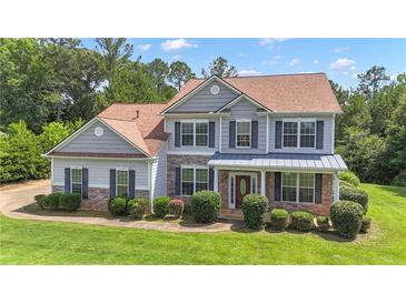 Charming two-story home with stone accents, manicured lawn, and covered front porch at 102 Plantation Dr, Lagrange, GA 30277