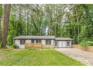 Ranch home with white painted brick, new fence, and new roof situated in a wooded lot at 2806 Hedgewood Nw Dr, Atlanta, GA 30311