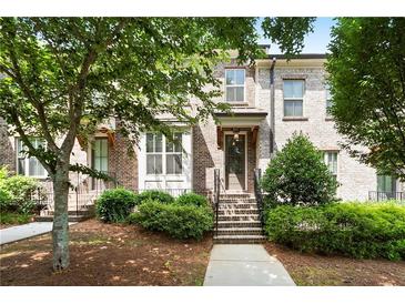 Charming brick townhouse with a well-manicured lawn and inviting entryway steps at 3657 Atherton Park Ct, Suwanee, GA 30024