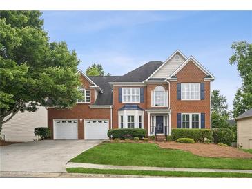 Beautiful two-story brick home featuring a two-car garage and lush green landscaping at 130 White Sands Ct, Suwanee, GA 30024