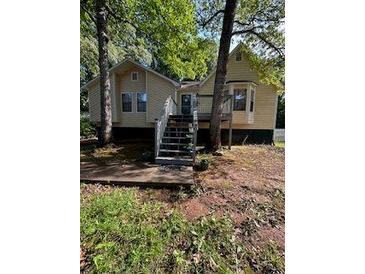 Inviting home featuring an exterior deck and stairs surrounded by mature trees at 4050 Willow Ridge Rd, Douglasville, GA 30135