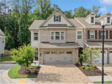 Beautiful brick-and-siding townhome with a well-manicured lawn and an attached two-car garage at 490 Duval Dr, Alpharetta, GA 30009