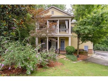 Charming two-story home featuring a welcoming front porch and second story balcony, surrounded by lush greenery at 635 Holcomb Bridge Rd, Norcross, GA 30071