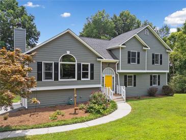 Charming home with gray siding, black shutters, and a cheerful yellow front door at 1400 Land Rd, Canton, GA 30114