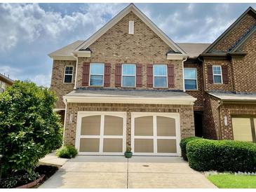 Charming brick townhome featuring a two-car garage and well-maintained landscaping at 3534 Clancy Way, Smyrna, GA 30080