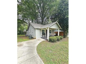 Charming single-story home featuring a covered porch with a swing, neat landscaping, and a paved driveway at 1341 Se Joyner Se Ave, Marietta, GA 30060
