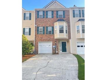 Two-story townhouse with brick facade, a driveway, attached garage and well-kept front yard at 795 Abbotts Mill Ct # 73, Johns Creek, GA 30097