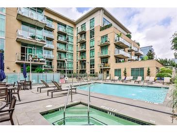 Inviting outdoor pool area with lounge chairs and a hot tub for relaxation in a modern condo complex at 905 Juniper Ne St # 701, Atlanta, GA 30309