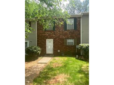 Charming brick townhouse with green shutters and a well-maintained front lawn, creating a welcoming curb appeal at 8955 Stonebridge Blvd, Douglasville, GA 30134