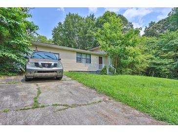 Charming single-story home with well-maintained front lawn and a long concrete driveway at 504 Rock Meadow Dr, Stone Mountain, GA 30088