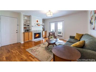 Inviting living room featuring a fireplace, hardwood floors, and access to a balcony at 1150 Collier Nw Rd # G8, Atlanta, GA 30318