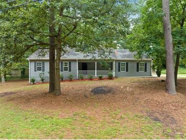 Charming single-story home features a symmetrical facade, gray siding, and a welcoming front porch at 3235 Harms Way, Snellville, GA 30039