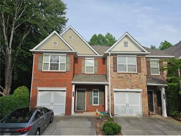 Charming townhome with a brick facade, attached garage, and well-maintained landscaping at 2131 Meadow Peak Rd, Duluth, GA 30097