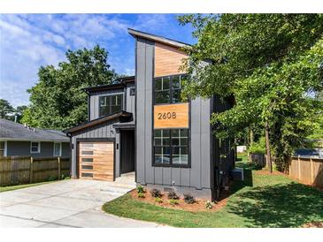 Modern two-story home featuring a gray facade, natural wood accents, and a stylish garage door at 2608 Argo Drive Southeast Se Dr, Smyrna, GA 30080