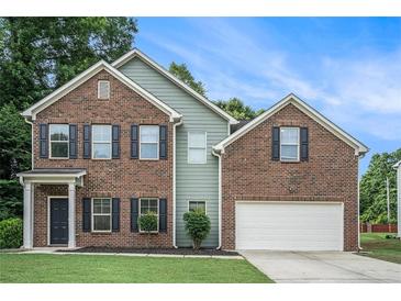 Charming two-story brick home with well-manicured lawn, attached two car garage, and inviting curb appeal at 2035 Stonebrook Dr, Austell, GA 30106