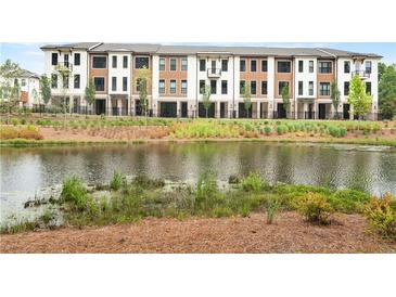 Townhome community featuring a pond, lush landscaping, and modern facades at 344 Olmstead Way # 32, Alpharetta, GA 30022