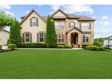 Charming two-story home with stone accents, manicured lawn, and tasteful landscaping at 4425 Martel Dr, Cumming, GA 30040