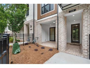 Inviting front entrance with brickwork, covered porch, and modern black door at 334 Olmstead Way # 37, Alpharetta, GA 30022