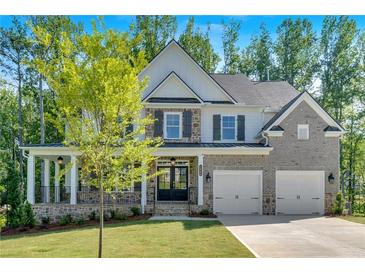 Charming two-story home with a manicured lawn, stone accents, and an attached two-car garage at 1065 Low Water Crossing Nw, Acworth, GA 30101
