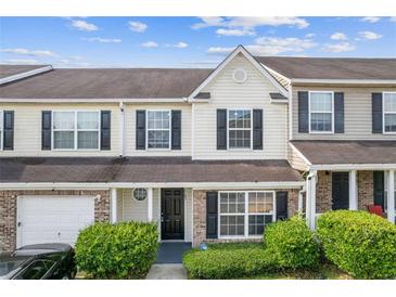 Charming two-story townhome with a manicured front yard and attached garage at 2183 Miranda Dr, Morrow, GA 30260
