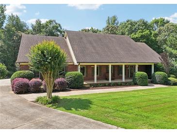 Charming brick home featuring a welcoming front porch and well-manicured lawn at 169 Robson Trl, Mcdonough, GA 30252