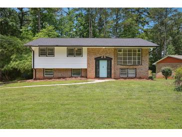 Charming brick home featuring a well-manicured lawn, classic architectural design, and a welcoming light blue front door at 3611 Radcliffe Blvd, Decatur, GA 30034