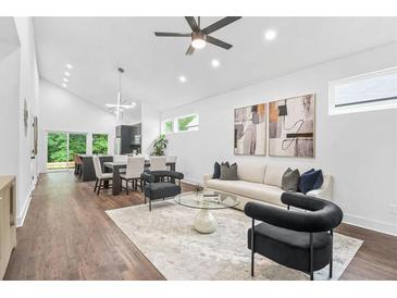 Bright, open living room features a modern ceiling fan, neutral color scheme, and hardwood flooring throughout at 587 Woods Nw Dr, Atlanta, GA 30318