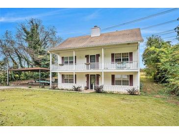 Charming two-story home featuring a welcoming porch on both levels and a spacious front yard with convenient carport at 4141 Willow Ridge Rd, Douglasville, GA 30135