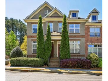 Charming townhome with well-manicured landscaping and a welcoming facade on a clear, sunny day at 7275 Highland Blf # 8, Atlanta, GA 30328