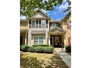 Charming townhome featuring low-maintenance landscaping and a welcoming covered entryway at 2706 Cedar Dr, Lawrenceville, GA 30043