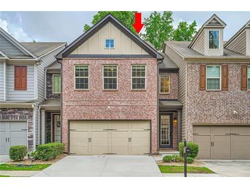 Charming two-story townhome with a two-car garage and manicured landscaping at 3280 Hallmark Ln, Buford, GA 30519