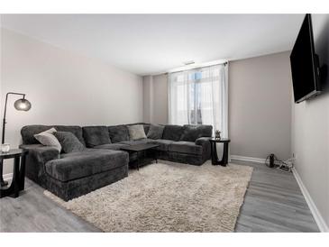 Comfortable living room showcasing a plush gray sectional sofa, soft rug, and stylish decor at 1421 Peachtree Ne St # 401, Atlanta, GA 30309