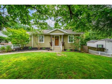 Charming home with a manicured lawn, featuring a cozy entrance and lush landscaping at 1734 8Th St, Brookhaven, GA 30341